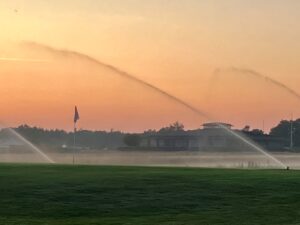 Sommeraften på banen med sprinklere og klubhus i Hals Seaside Golfklub