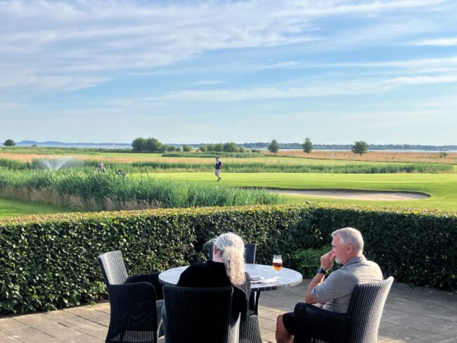 Golfcaféens terrasse med panorama over banerne og fjorden i Hals