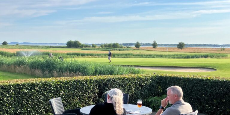 Golfcaféens terrasse med panorama over banerne og fjorden i Hals