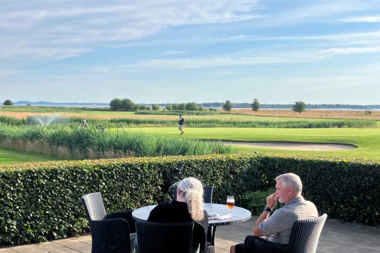 Golfcaféens terrasse med panorama over banerne og fjorden i Hals